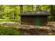 Charming shed featuring a green door, set amidst a picturesque landscape with greenery and stone accents at 5800 Lawrence Dr, Indianapolis, IN 46226