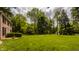 Expansive, well-maintained front lawn surrounding a classic brick home and mature trees at 5800 Lawrence Dr, Indianapolis, IN 46226