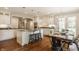 Bright kitchen with white cabinets, granite countertops, an island with stools, and a dining area at 5800 Lawrence Dr, Indianapolis, IN 46226