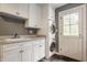 Bright laundry room features modern washer/dryer, sink, and white cabinets for ample storage at 5800 Lawrence Dr, Indianapolis, IN 46226