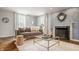 Comfortable living room featuring hardwood floors, a gray sofa, and a fireplace with a round mirror at 5800 Lawrence Dr, Indianapolis, IN 46226