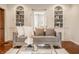 Comfortable living room featuring hardwood floors, a gray sofa, and built-in bookshelves at 5800 Lawrence Dr, Indianapolis, IN 46226