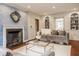 Comfortable living room featuring hardwood floors, a gray sofa, and a fireplace with a decorative mirror at 5800 Lawrence Dr, Indianapolis, IN 46226