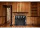 Living room featuring wood paneling, fireplace with marble surround, and built-in shelving at 5800 Lawrence Dr, Indianapolis, IN 46226