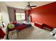 Unique bedroom with a racecar bed, red accent wall, carpeted floor, and a window offering natural light at 6309 Harvey Dr, Plainfield, IN 46168