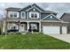 Charming two-story home with blue siding, brick accents, manicured lawn, and a welcoming front porch at 6309 Harvey Dr, Plainfield, IN 46168