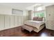 Bright main bedroom featuring hardwood floors, a high ceiling, and built-in cabinets on either side of a window at 6505 Miramar Ct, Indianapolis, IN 46250