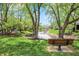 Peaceful view of a pond from a park bench surrounded by mature trees in a well-maintained community at 6505 Miramar Ct, Indianapolis, IN 46250