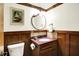A traditional half bathroom showcasing wood paneling, a stylish vanity with a red counter, and tasteful decor at 6505 Miramar Ct, Indianapolis, IN 46250