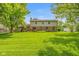 Spacious backyard with green lawn and a two-story home with a combination of brick and vinyl siding at 6530 Kingswood Dr, Indianapolis, IN 46256