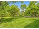 Expansive green lawn with meticulously striped grass surrounded by mature trees and shrubs at 6530 Kingswood Dr, Indianapolis, IN 46256