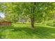Lush backyard features a well-maintained lawn and mature trees, offering a private retreat at 6530 Kingswood Dr, Indianapolis, IN 46256