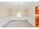 Open dining room with neutral carpet, wainscoting, chandelier and natural light at 6530 Kingswood Dr, Indianapolis, IN 46256