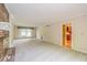 Empty living room with fireplace, bright window and access to an adjacent kitchen at 6530 Kingswood Dr, Indianapolis, IN 46256