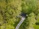 Aerial view of a home nestled in a wooded area with a long driveway and lush greenery at 6682 English Dr, Avon, IN 46123