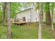 A large backyard and deck behind this bright white house with a dark roof and light green foliage all around at 6682 English Dr, Avon, IN 46123