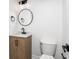 Modern bathroom featuring a round mirror, wood vanity, and black fixtures at 6682 English Dr, Avon, IN 46123