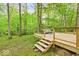 View of new wooden deck and railings and deck furniture, surrounded by lush greenery and mature trees at 6682 English Dr, Avon, IN 46123