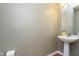 Simple half-bathroom featuring a pedestal sink, a large mirror, and modern fixtures at 6839 Powder Dr, Indianapolis, IN 46259