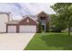 Charming two-story brick home with a well-manicured lawn, mature tree, and an attached two-car garage at 6839 Powder Dr, Indianapolis, IN 46259