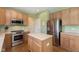 Modern kitchen featuring stainless steel appliances, wooden cabinets, an island, and a hardwood floor at 6839 Powder Dr, Indianapolis, IN 46259
