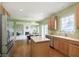 Open kitchen features stainless steel appliances, wood cabinets, an island, and hardwood floors at 6839 Powder Dr, Indianapolis, IN 46259