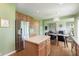 Spacious kitchen showcases a large stainless steel refrigerator, wood cabinets, a center island, and hardwood floors at 6839 Powder Dr, Indianapolis, IN 46259