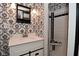 A stylish bathroom featuring decorative wallpaper, a modern vanity, and a tiled shower stall at 7228 Kimberly Ln, Plainfield, IN 46168