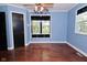 Bright bedroom with hardwood floors, a ceiling fan, and two windows with views of the yard at 7228 Kimberly Ln, Plainfield, IN 46168