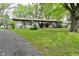 Charming single-story home with well-manicured lawn, mature trees, long driveway, and an American flag at 7228 Kimberly Ln, Plainfield, IN 46168