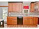 A charming kitchen featuring wooden cabinets, decorative wallpaper, and modern appliances at 7228 Kimberly Ln, Plainfield, IN 46168