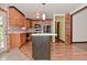 Kitchen featuring an island, wooden cabinets, stainless appliances, and tile and wood flooring at 7228 Kimberly Ln, Plainfield, IN 46168