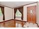 Cozy living room featuring hardwood floors, neutral walls, and a front door at 7228 Kimberly Ln, Plainfield, IN 46168