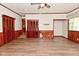 A well-lit living room with wood-look floors, paneled walls, and closet space at 7228 Kimberly Ln, Plainfield, IN 46168