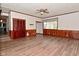 An open living room featuring wood-look floors, paneled walls, and access to other rooms at 7228 Kimberly Ln, Plainfield, IN 46168