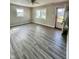 Bright living room with modern vinyl floors, fresh paint and natural light from two windows at 728 Lonsvale Dr, Anderson, IN 46013