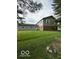 A large, green backyard featuring a spacious lawn, a house and several trees at 7835 Caswell St, Indianapolis, IN 46259
