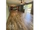Open concept living room featuring updated hardwood floors and open door leading to outdoors at 7835 Caswell St, Indianapolis, IN 46259