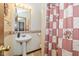 Bathroom featuring a pedestal sink, decorative mirror and a vintage patterned shower curtain at 8111 Timberwood Dr, Plainfield, IN 46168