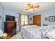 Cozy bedroom featuring soft blue walls, a ceiling fan, and a comfortable bed with a gray patterned comforter at 8111 Timberwood Dr, Plainfield, IN 46168