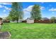 This expansive backyard features a lush lawn, a shed, and mature trees, offering space at 815 Stewart Rd, Anderson, IN 46012