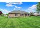 Expansive backyard featuring a well-maintained lawn and brick exterior, perfect for outdoor enjoyment and relaxation at 815 Stewart Rd, Anderson, IN 46012