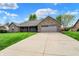 Well-manicured front yard and attached garage compliment this beautiful one-story brick home at 815 Stewart Rd, Anderson, IN 46012