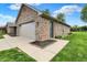 Exterior view of a brick house with a two-car garage and landscaped yard at 815 Stewart Rd, Anderson, IN 46012
