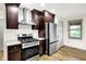 A kitchen featuring stainless steel appliances, granite countertops, and dark wood cabinetry at 815 Stewart Rd, Anderson, IN 46012