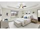 A spacious main bedroom with a tray ceiling, ceiling fan, and neutral color scheme at 815 Stewart Rd, Anderson, IN 46012