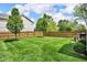Expansive backyard featuring a well-maintained lawn and a classic wooden fence for privacy at 8704 New Heritage Dr, Indianapolis, IN 46239