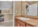 Bathroom featuring vanity with laminate countertops and a decorative mirror offering hallway view at 8704 New Heritage Dr, Indianapolis, IN 46239