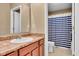 Bathroom featuring a vanity with laminate countertop, a decorative mirror, and a shower with blue-striped shower curtain at 8704 New Heritage Dr, Indianapolis, IN 46239