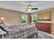 Cozy bedroom with natural light, large dresser, ceiling fan, and a comfortable bed with stylish bedding at 8704 New Heritage Dr, Indianapolis, IN 46239